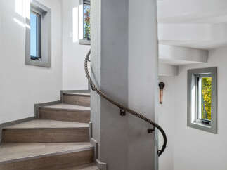 Ascend this modern spiral staircase, featuring durable wood-look flooring and sleek metal accents.