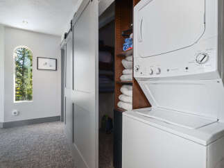 Discover the convenience of in-unit laundry with this stacked GE washer and dryer, perfectly integrated into a spacious closet.