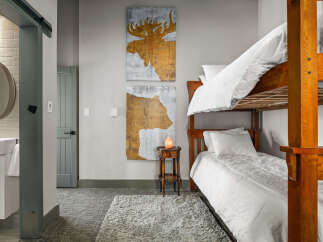 Experience rustic charm in this cozy bedroom featuring a sturdy wooden bunk bed, perfect for family or guests.