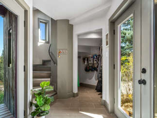 Step into this inviting entryway featuring a modern staircase with a sleek metal railing.