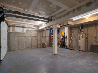 Discover ample storage and utility in this spacious garage, featuring a durable concrete floor and walls.
