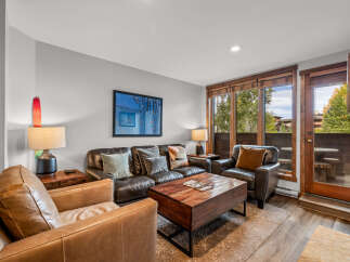 Experience cozy living in this inviting living room, featuring plush leather seating and a rustic wooden coffee table perfect for gatherings.
