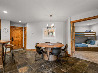 This charming space features a rustic wooden dining table with black chairs, perfect for family meals.