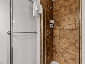Step into this inviting shower featuring rich, textured brown tile walls that create a warm and earthy ambiance.