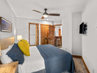 Experience comfort and style in this inviting bedroom, featuring a plush bed adorned with navy and yellow accents.