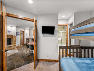 This inviting space features a cozy bunk bed with blue quilted bedding, perfect for accommodating guests.