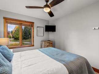 Experience comfort and style in this inviting bedroom, featuring a plush bed adorned with soft blue pillows and a cozy quilted comforter.