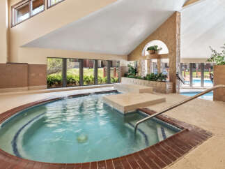 Indulge in relaxation in this indoor spa featuring a spacious hot tub with soothing jets and a built-in seating area.