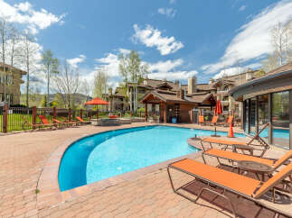 Enjoy a refreshing dip in the sparkling blue pool, surrounded by a beautifully paved patio and comfortable lounge chairs.
