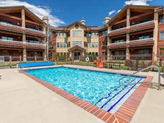 Enjoy a refreshing dip in the sparkling blue swimming pool, complete with a convenient cover and sturdy metal railings for easy access.
