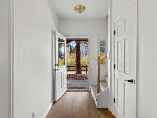 Step into a welcoming entryway with beautiful wood-look flooring and crisp white walls.