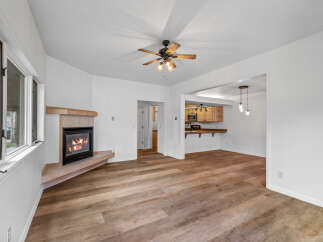Cozy up by the fireplace in this inviting living space, featuring a beautiful wood-burning fireplace with a tile surround and a wooden mantle.