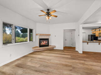 Cozy up by the fireplace in this inviting living space, featuring a beautiful corner fireplace with a natural wood mantle.