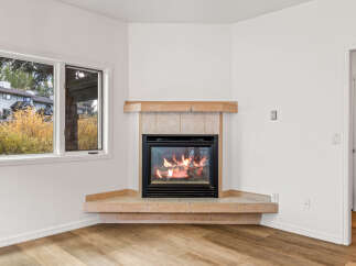 Cozy up by the corner fireplace, featuring a warm wood mantel and tiled surround, perfect for chilly evenings.