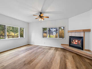Cozy up by the fireplace in this inviting living room, featuring a beautiful wood-burning hearth.