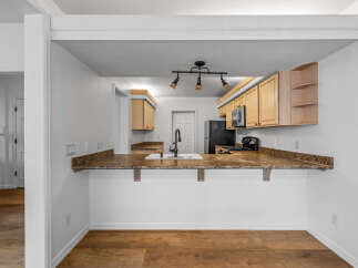 Step into this charming kitchen, featuring light wood cabinetry and granite countertops that offer a warm and inviting atmosphere.