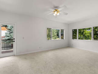 Step into this bright and airy bedroom, featuring plush carpeting and a convenient ceiling fan for year-round comfort.