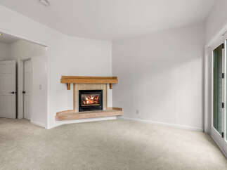 Cozy up by the fireplace in this inviting living space, featuring a beautiful wooden mantel and a tiled surround.
