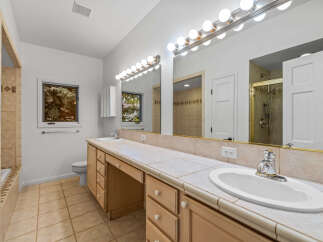 This spacious bathroom features a long vanity with dual sinks and ample counter space, perfect for busy mornings.
