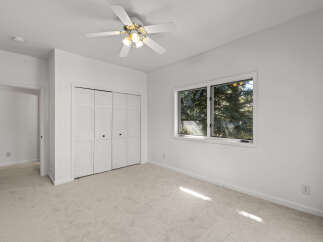 This bedroom features a spacious feel with neutral carpeting and clean white walls.