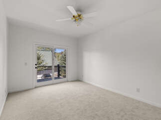 Step into this bright and airy bedroom, featuring plush carpeting and a convenient ceiling fan for year-round comfort.