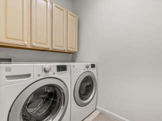 This laundry room features a white Kenmore front-load washer and dryer set, perfect for handling all your laundry needs.