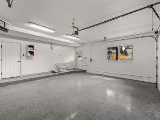 Discover this spacious garage featuring a durable epoxy-coated floor, perfect for protecting against spills and wear.