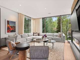 Experience luxurious living in this stunning modern living room, featuring a spacious sectional sofa perfect for gatherings and a cozy fireplace for warm evenings.