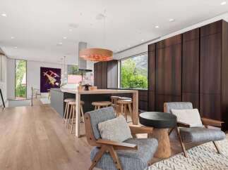 Experience modern luxury in this open-concept living space, featuring a sleek kitchen island with bar seating and a striking pendant light.