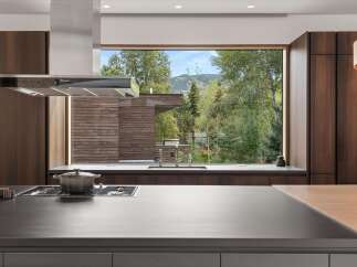 Experience luxury living in this modern kitchen, featuring sleek dark wood cabinetry and a spacious island perfect for entertaining.