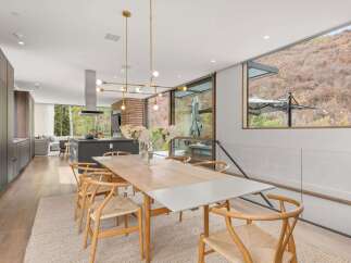 Experience modern living in this stunning dining area, featuring a sleek wooden dining table and elegant wishbone chairs.