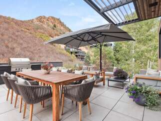 Experience luxurious outdoor living on this expansive patio, featuring a built-in grill and a spacious dining area perfect for entertaining.