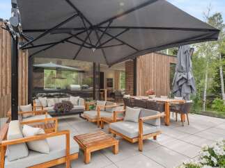 Experience luxurious outdoor living with this expansive patio featuring a large cantilever umbrella providing ample shade.