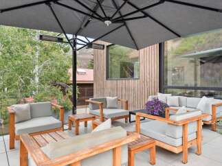 Enjoy outdoor living at its finest on this spacious patio, complete with comfortable seating and a large umbrella for shade.