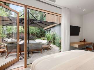 Experience seamless indoor-outdoor living with expansive glass doors opening to a serene backyard oasis.