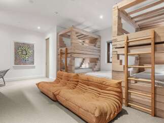 This unique bedroom features custom-built wooden bunk beds, offering a rustic and adventurous sleeping arrangement.