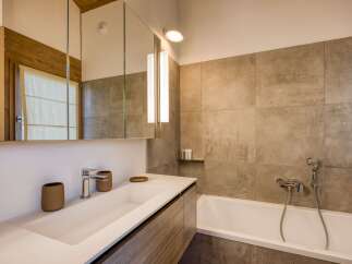 Experience modern comfort in this beautifully appointed bathroom, featuring a sleek white sink and vanity with ample storage.