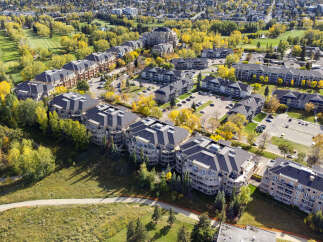 Discover modern living in this aerial view of a residential complex surrounded by lush greenery and vibrant autumn foliage.