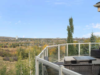 Enjoy breathtaking panoramic views from this stunning property, featuring a spacious deck with modern glass railings perfect for entertaining.
