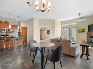 This open-concept living space features a modern kitchen with ample cabinet space and a breakfast bar, perfect for casual dining.
