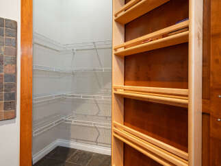 Discover ample storage solutions in this pantry, featuring versatile white wire shelving that maximizes space and organization.