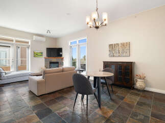 Experience comfortable living in this spacious living and dining area, featuring a cozy fireplace and a large television.