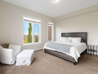 Experience comfort and style in this beautifully appointed bedroom, featuring a spacious king-sized bed with crisp white linens and a decorative grey throw.