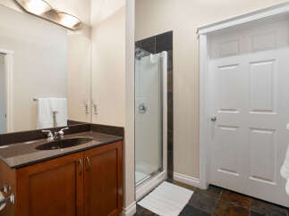 This bathroom features a spacious vanity with a granite countertop and a dark wood cabinet, offering ample storage.