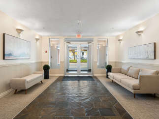 Step into a welcoming entryway featuring a modern design with comfortable seating areas.