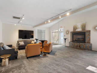 This spacious living area features a cozy fireplace with a tiled surround, perfect for gathering with loved ones.