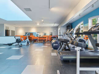 This spacious gym features a variety of cardio equipment, including treadmills and ellipticals, perfect for a full-body workout.