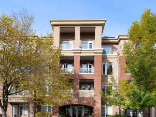 Discover modern living in this stunning apartment building, featuring a striking facade of red brick and beige stucco.