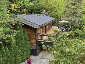 Nestled amidst lush greenery, this charming wooden cabin offers a serene retreat.