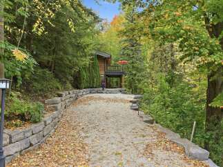 Embrace the beauty of autumn with this charming home nestled amidst vibrant fall foliage.